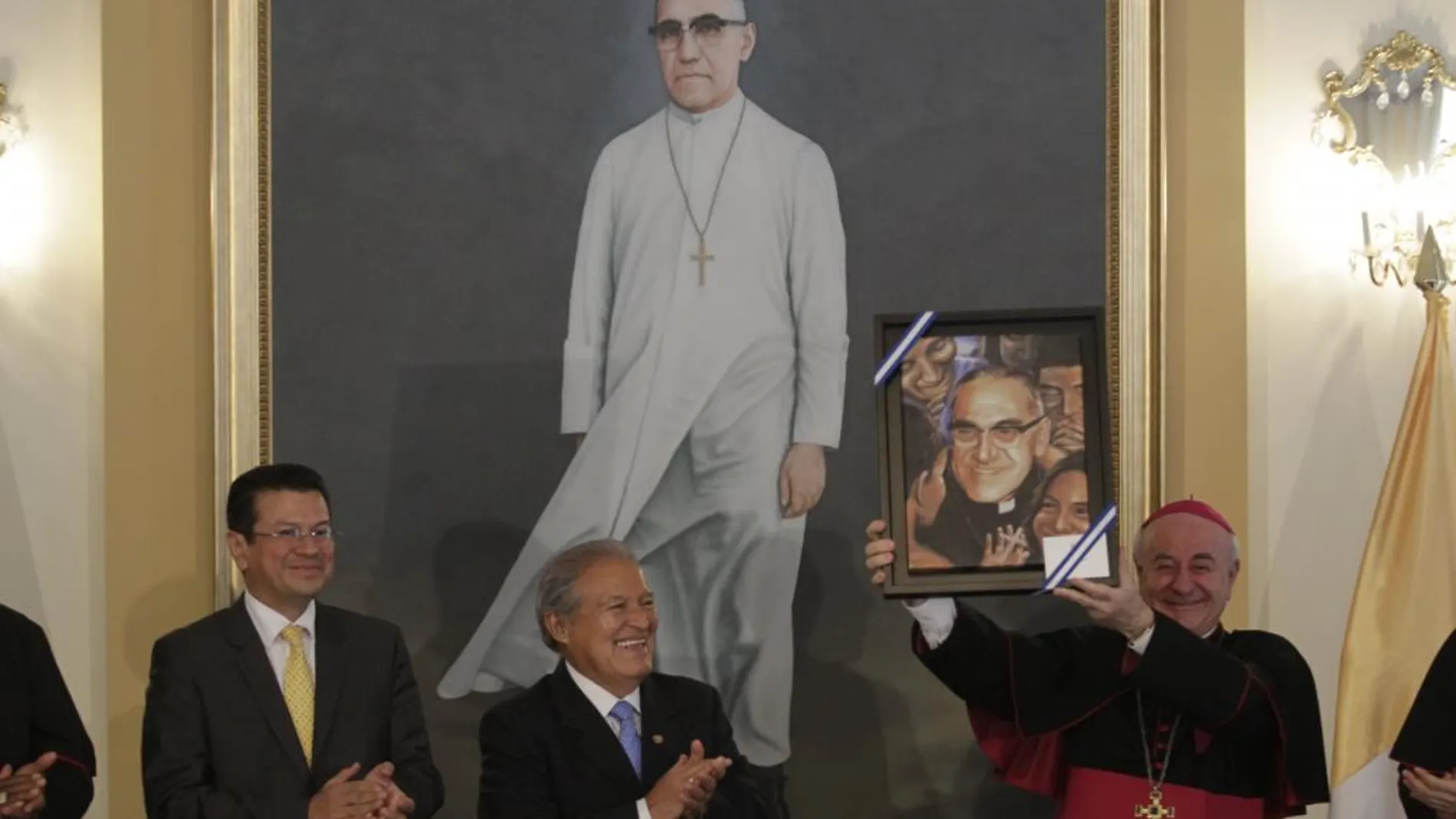 El arzobispo Vincenzo Paglia (d), sujeta un retrato de monseñor Oscar Romero, el pasdado día 11 de marzo, junto al ministro de exteriores de El Salvador, Hugo martínez (i), y el presidente del país, Salvador Sánchez Ceres (c)