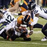 El receptor de los Denver Broncos Trindon Holliday (centro) recibe un placaje de Jeremy Lane y Robert Turbin (dcha) de los Seattle Seahawks durante la final de la Super Bowl