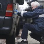 Un agente de policía forense toma fotografías de un vehículo estacionado en el exterior de la vivienda de la calle Colline Street en Verviers, donde el jueves tuvo lugar una operación antiterrorista contra presuntos yihadistas, en el este de Bélgica