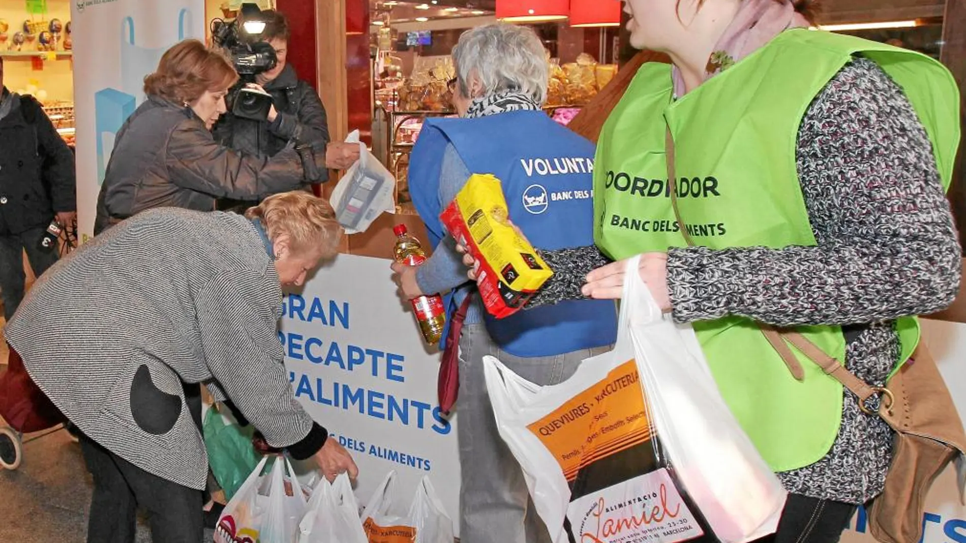 En la imagen, varios ciudadanos entregan alimentos para la campaña del Gran Recapte