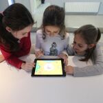 Tres niñas jugando con una tableta