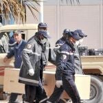 Operarios trasladan los ferétros de las víctimas, ayer, en In Amenas