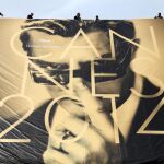 Varios empleados cuelgan un póster de la 67ª edición del Festival de Cannes en la fachada del Palais de Festivals, en Cannes