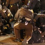 Varios policías detienen a unos manifestantes a las afueras del Departamento de Policía de Ferguson
