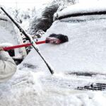 Una persona retira la nieve y el hielo de su coche en Lugo