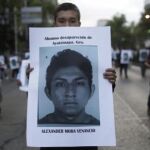 Un manifestante porta un cartel con la fotografía de Alexander Mora Venancio, el estudiante indentificado por los restos