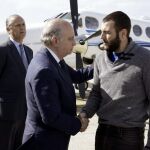 Jorge Fernández Díaz recibiendo al policía nacional y espeleólogo Juan Bolívar Bueno (d), tras su llegada al aeródromo de Cuatro Vientos de Madrid.