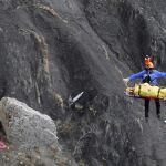 Un miembros de los equipos de rescate traslada uno de los cuerpos