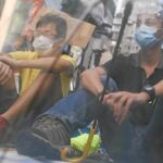 Dos activistas prodemocracia se protegen de un posible ataque de la Policía con un paraguas, en Hong Kong