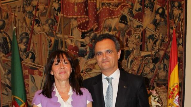 El embajador de Portugal, don Francisco Ribeiro de Menezes y su señora, posando el día de la Fiesta Nacional delante de las banderas de Portugal y España.