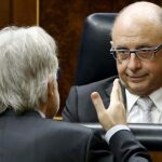 Cristóbal Montoro, conversa con el diputado de CiU Josep Sánchez Llibre (de espaldas), hoy en el Congreso, durante el debate sobre el proyecto de ley de Presupuestos Generales del Estado 2015.