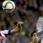 Saúl Ñíguez (i), salta por el balón con el galés Gareth Bale