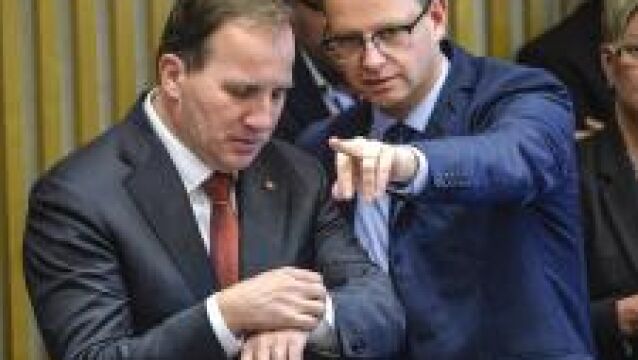 Stefan Lofven consulta su reloj junto a Mikael Damberg