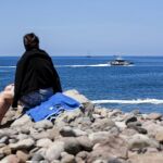 Una patrullera de la Guardia Civil, al fondo, en busca de rastros de fuel en la playa Veneguera, en Gran Canaria