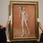 Dos operarios cuelgan el cuadro «Los dos Hermanos» (1905) de Pablo Picasso en la presentación de la Exposición del pintor malagueño en el Museo del Prado