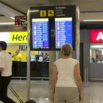 na persona comprueba el estado de un vuelo en una pantalla en la jornada de huelga de controladores aéreos.