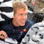 El piloto alemán Sebastian Vettel, de la escudería Red Bull, firma autógrafos después de la sesión de clasificación del Gran Premio de Gran Bretaña de Fórmula Uno