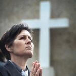 Una mujer en pleno rezo del rosario