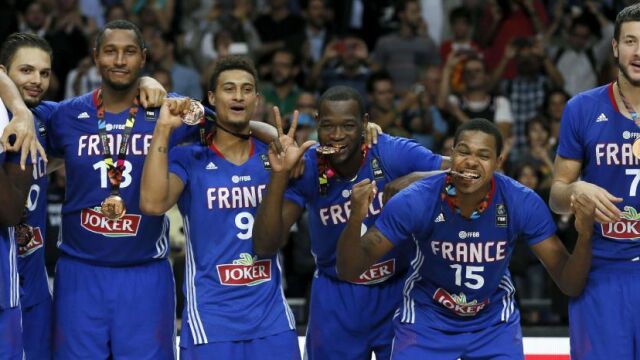 El alero francés Michael Gelabale (2d), junto con sus compañeros muerden la medalla de bronce mientras celebran la victoria sobre Lituania en el partido del Mundial de Baloncesto 2014