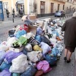 Una mujer trata de sortear en el Pumarejo los desperdicios que ocupan la acera
