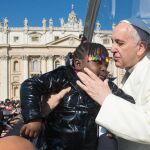 Francisco besa a una niña en el Vaticano