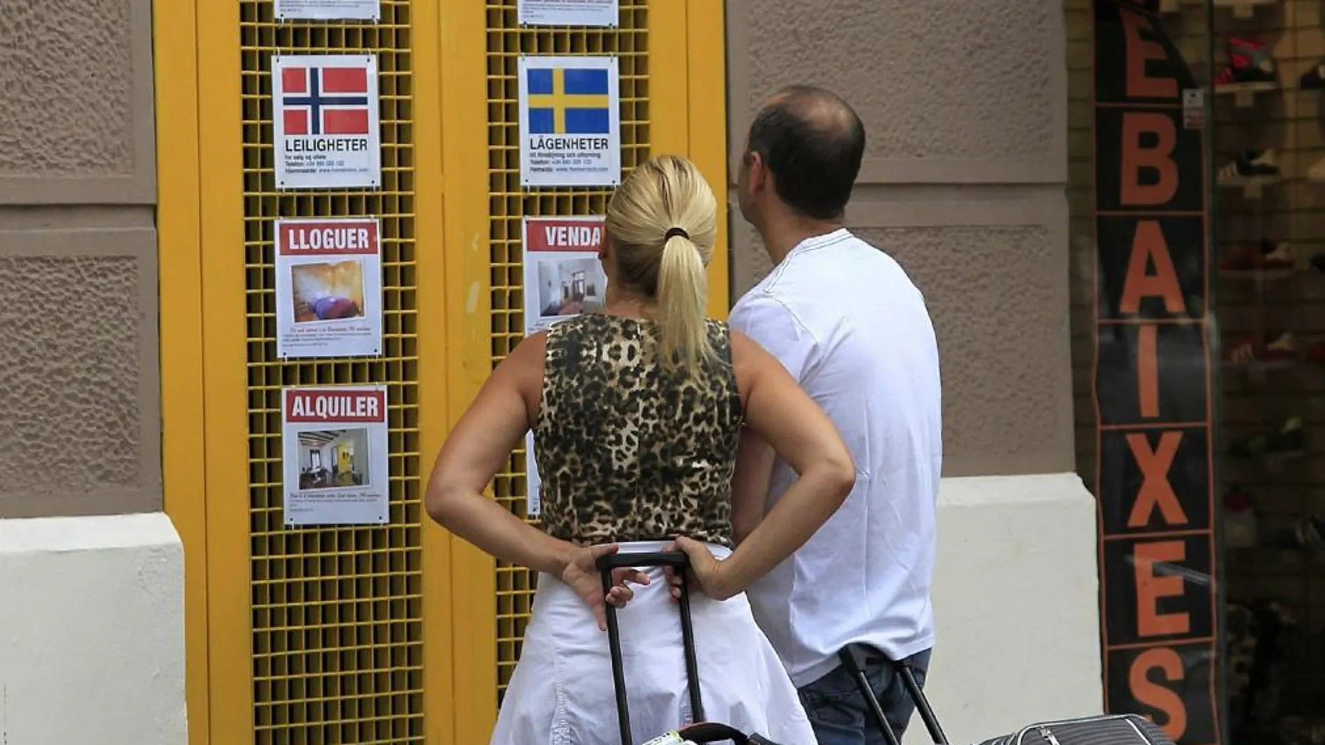 Una pareja ojea opciones de pisos turísticos en el barrio de La Barceloneta