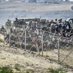 Los inmigrantes junto a la valla