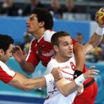 El extremo de España Víctor Tomás (d) intenta superar la defensa de los jugadores de Egipto