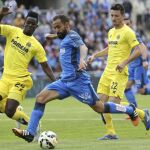 El jugador del Getafe Diego Castro (c) avanza con el balón ante la defensa de Bailly (i) y Rukavina, del Villarreal
