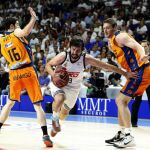 El base del Real Madrid Sergio Llull (c) pugna un balon con el ucraniano Serguéi Lischuk (d) y Guillem Vives, del Valencia Basket