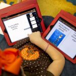 Una niña con dos tablets en clase