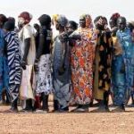 Mujeres sursudanesas se preparan en cola para recibir alimentos