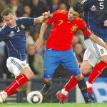 Villa disputa el balón con dos defensas escoceses en el encuentro del martes