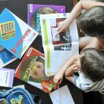 Laura, de 8 años, y su hermano Matías, de 5, miran ilusionados los libros del nuevo curso escolar que empiezan el martes