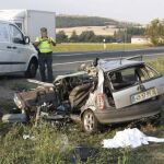 Un agente de la Guardia Civil inspecciona el Opel Corsa con matrícula portuguesa que protagonizó el siniestro