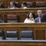 Soraya Sáenz de Santamaría (d), conversa con Jorge Fernández Díaz), mientras el diputado del PP Leopoldo Barreda (atrás) marca el sentido del voto para su grupo, esta tarde durante el pleno del Congreso.