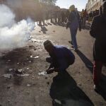 Vecinos partidarios de la expulsión de extranjeros observan un coche incendiado en un ataque xenófobo registrado en el centro de Johannesburgo