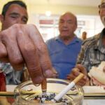 Socios del club almuerzan mientras fuman unos cigarrillos