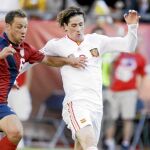 Fernando Torres intenta avanzar con el balón controlado ante la presión del futbolista de Estados Unidos Cherundolo