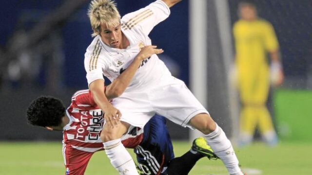 Fabio Coentrao lucha un balón contra un jugador del Chivas