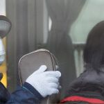 Unas japonesas, en un autobús, con mascarillas para protegerse.
