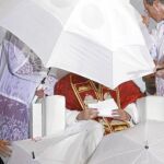 Los acólitos protegen al Santo Padre durante la vigilia de oración cuando el temporal arreció en el aeródromo