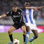 El centrocampista keniata de la Real Sociedad, Macdonald Mariga (d), pelea un balón con el centrocampista portugués del Granada Carlos Martins