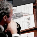 Un diputado italiano lee un artículo sobre el escándalo sexual de Berlusconi, ayer, durante la votación en la Cámara de Diputados
