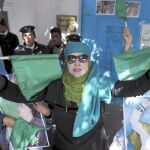 Una simpatizante de Gadafi porta dos banderas verdes, símbolo del régimen, ayer en Trípoli