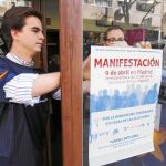 Voluntarios colocan carteles llamando a acudir a la marcha