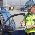 Un agente cobra una multa en una reciente campaña de control de velocidad de la Guardia Civil