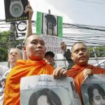 Dos monjes birmanos sujetan una pancarta con la cara de la opositora Aung San Suu Kyi, premio Nobel de la Paz y en arresto domiciliario