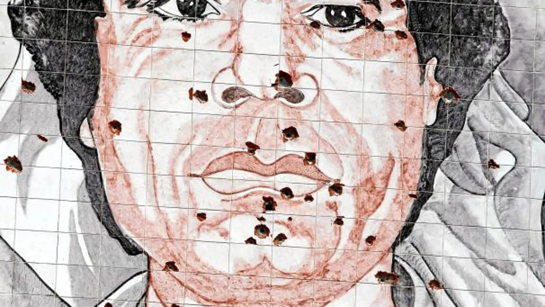Un retrato de Muamar Gadafi repleto de impactos de bala en Trípoli
