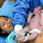 En la imagen, una mujer da a luz a su bebé